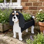 Cavalier King Charles Spaniel dog planter filled with fresh flowers is placed in the garden