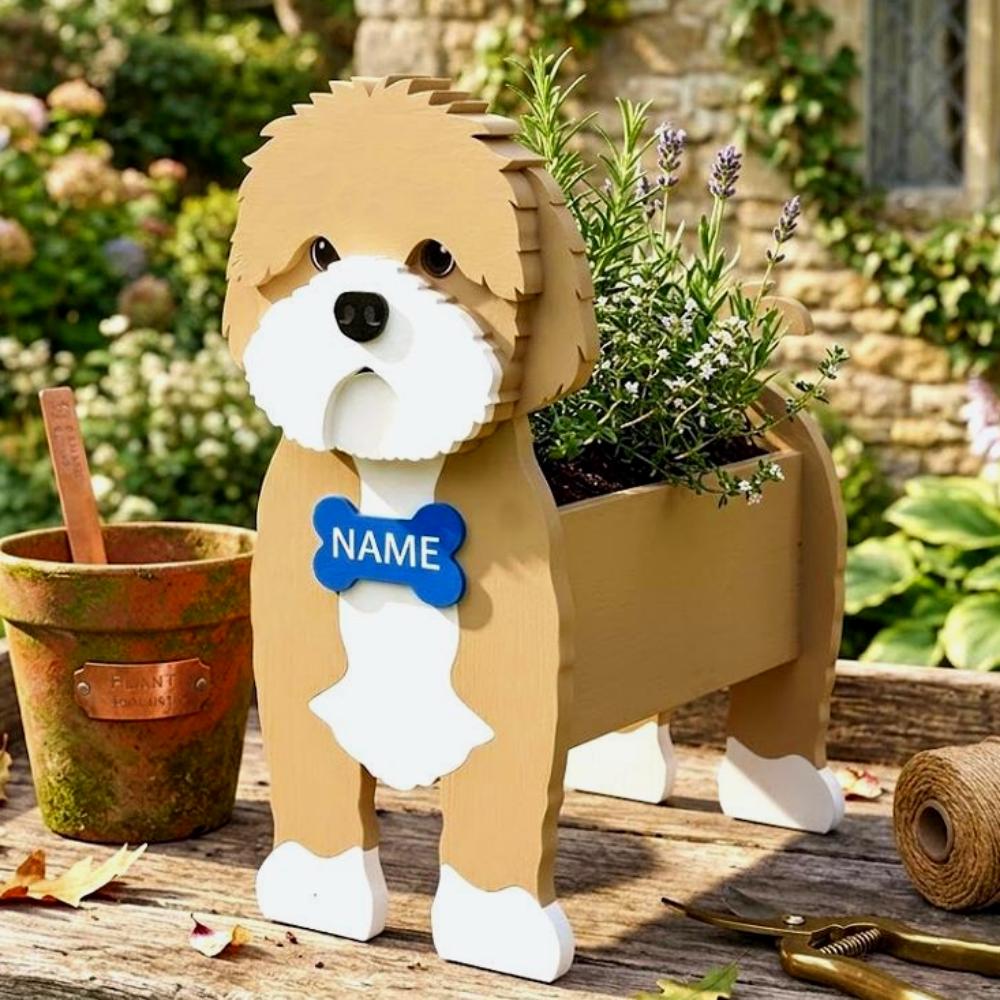 Cavapoo-shaped dog planter with a name tag on a wooden table in a garden setting