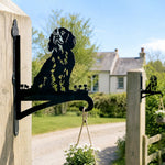 Cocker spaniel metal hanging basket bracket mounted on outdoor wall for plant decoration