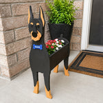 Doberman dog planter filled with fresh flowers is placed in the garden