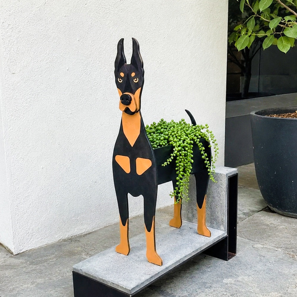 Doberman dog planter filled with fresh flowers is placed in the garden