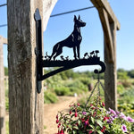 Doberman pinscher metal hanging basket bracket mounted on outdoor wall for plant decoration