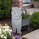 Exotic Shorthair cat planter filled with fresh flowers is placed in the garden