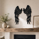 Black metal Fallen Angel wings wall art with intricate cutout details displayed on the wall