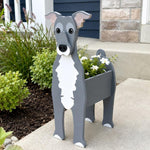 Greyhound dog planter filled with fresh flowers is placed in the garden