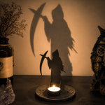 Grim reaper halloween metal candle holder casting a spooky shadow on the wall