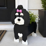 Havanese dog planter filled with fresh flowers is placed in the garden