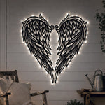 Black metal Heart Angel wings wall art with Soft White LED Lighting displayed on the wall