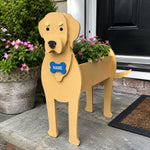 Labrador dog planter filled with fresh flowers is placed in the garden