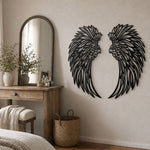 Black metal angel wings wall art displayed on a living room wall