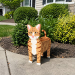 Orange Tabby cat planter filled with fresh flowers is placed in the garden