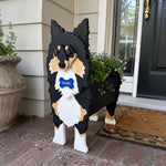 Sheltie-Shetland Sheepdog planter filled with fresh flowers is placed in the garden