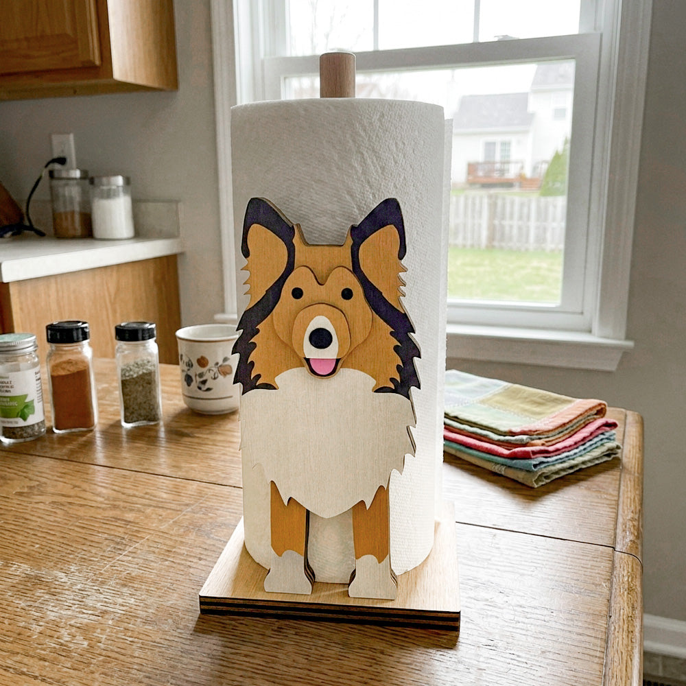 Shetland Sheepdog Wooden Dog Paper Towel Holder displayed on a kitchen countertop with a freestanding paper towel roll